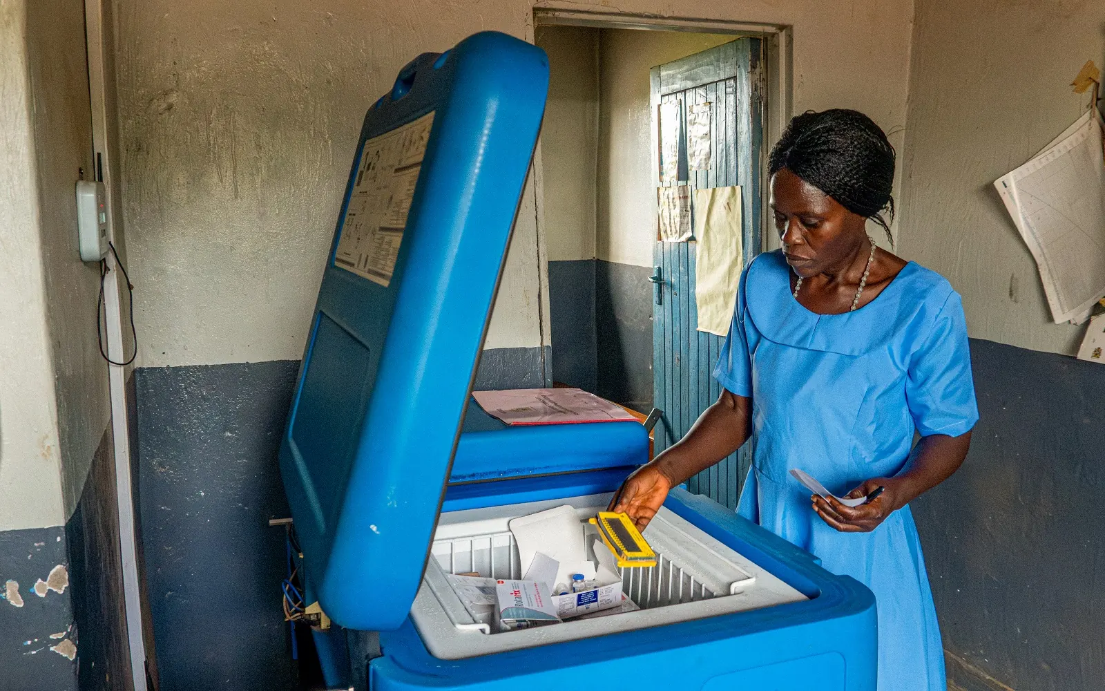 Nurse taking vaccines from a solar-powered cold-chain refrigerator