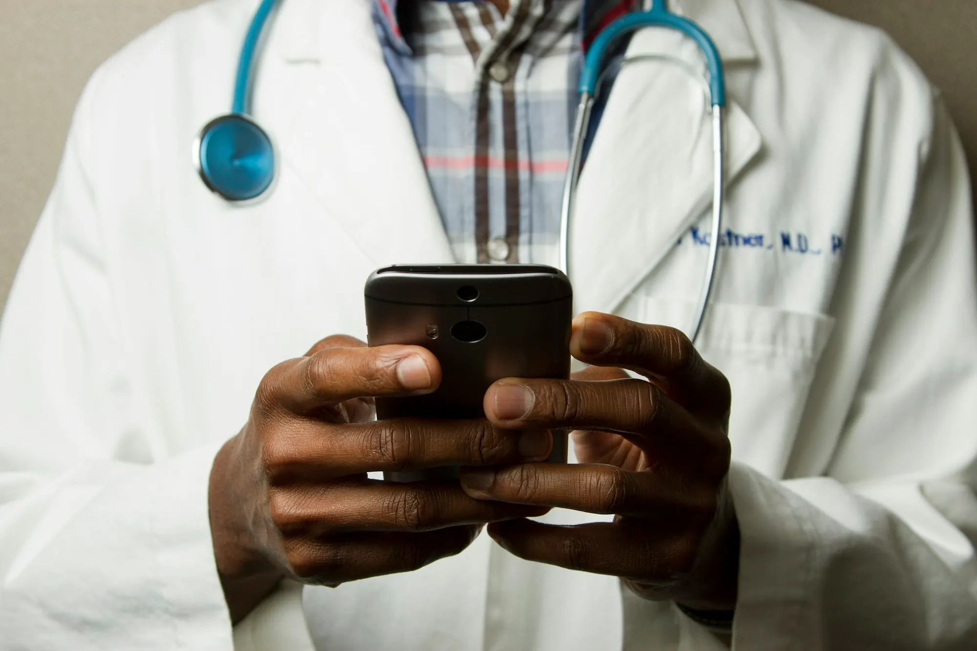 Clinician with a stethoscope using a smartphone