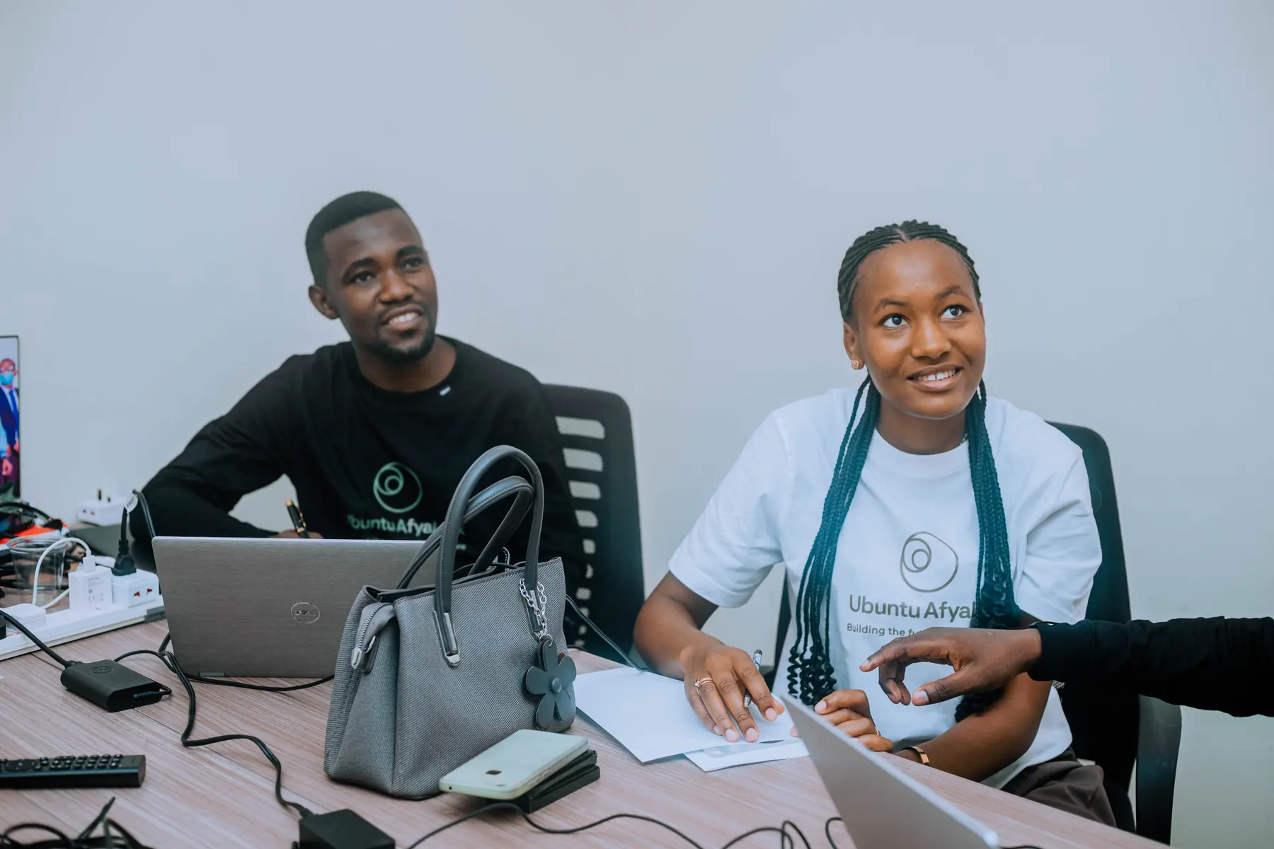 Two young AfyaLink team members smiling during a planning session