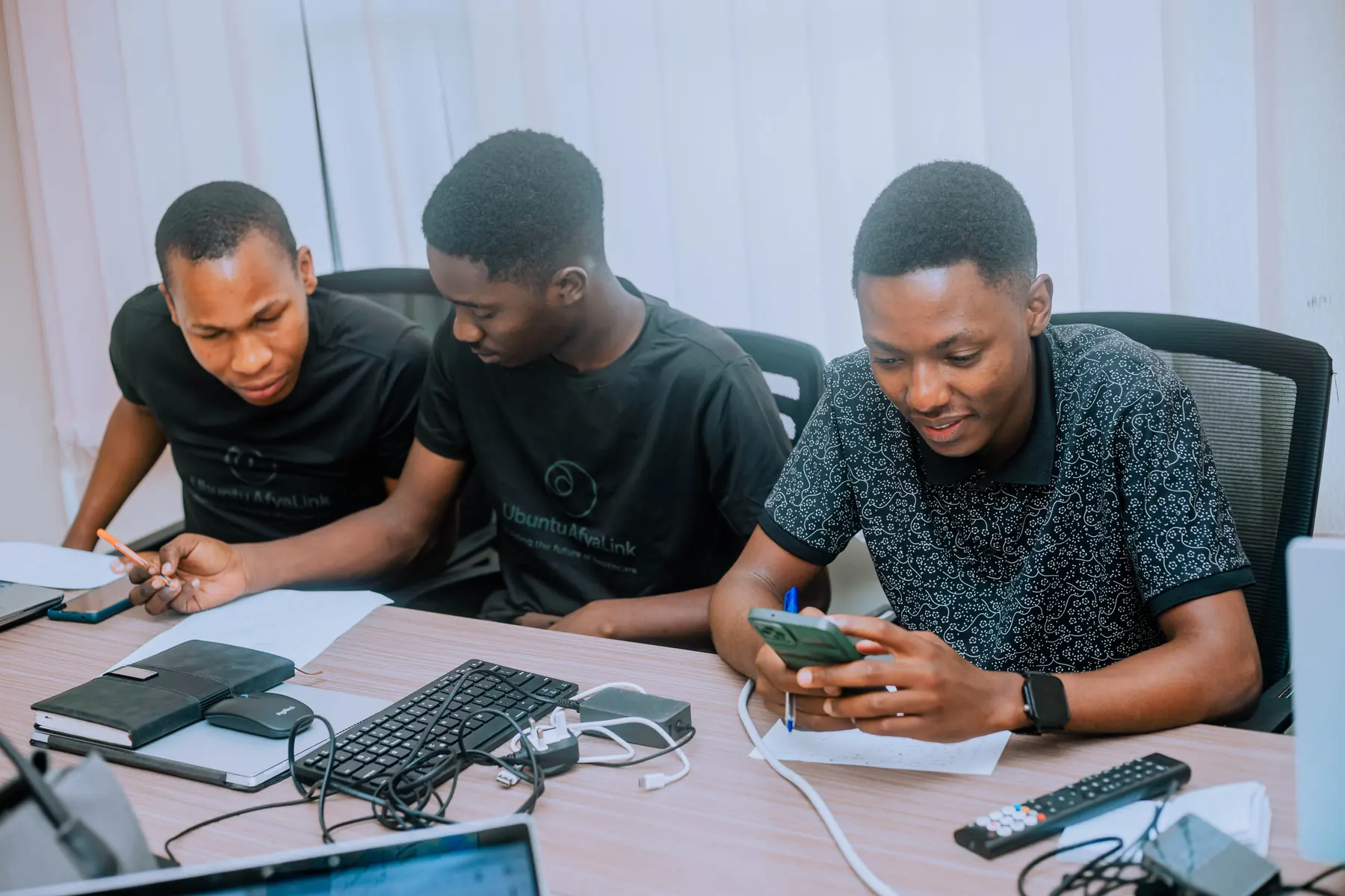 Young AfyaLink engineers collaborating at laptops